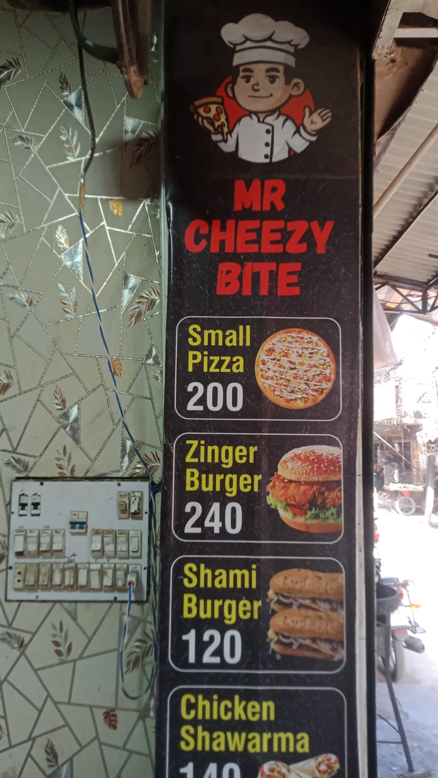 Shop banner listing small pizza, zinger, shami burger and shawarma